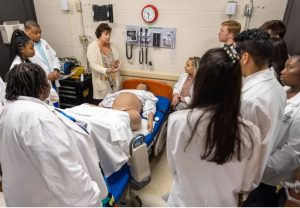 Kim Jackson, assistant director of the Innovative Learning Center, center, speaks to students, including Christian Hollis, top left, during the Mississippi Rural Physicians Scholarship Program Medical Encounter workshop at William Carey University in Hattiesburg, Miss., Monday, April 11, 2022. Credit: Eric Shelton/Mississippi Today
